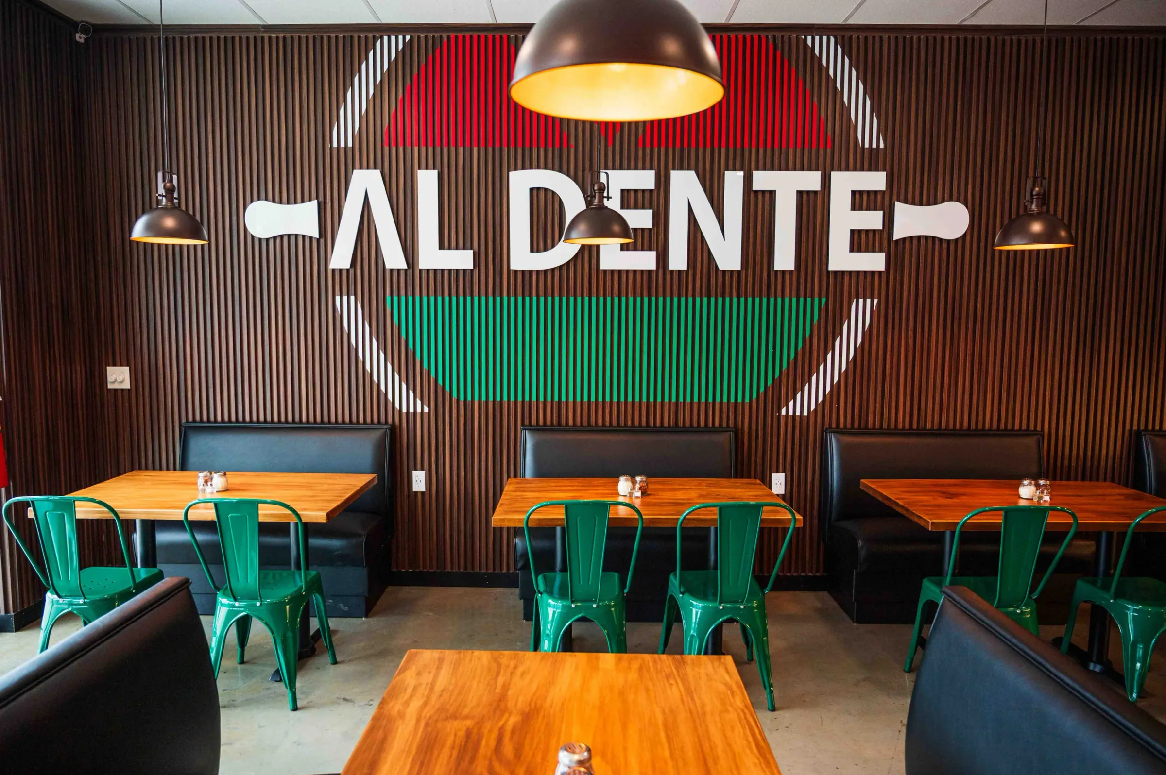 The Hoschton dining room with the Al Dente logo painted across the slatted wood wall